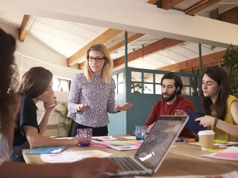 Equipe reunida em volta de uma mesa em um escritório, conversando sobre a organização de uma associação